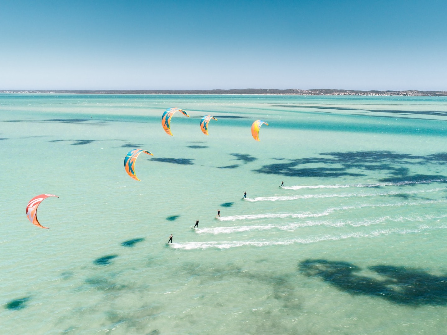 five people paragliding at the sea during daytime